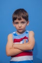 Boy in a striped t-shirt poses as a model on a blue background