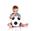 Baby boy sitting and playing a classic soccer ball on a white background. Royalty Free Stock Photo