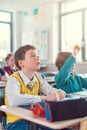 Boy student in class knowing an answer raising his hand Royalty Free Stock Photo