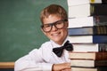 Boy student, smile and portrait with books, classroom and learning for exam, assessment and studying for knowledge Royalty Free Stock Photo