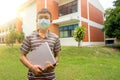 Boy student standing on grass field, children holding laptop for learinging on building school background Royalty Free Stock Photo