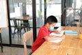 Boy student wearing face mask  studying writing notes doing homework. learning education at school Royalty Free Stock Photo