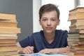 Boy studing at table on blue background and many book Royalty Free Stock Photo