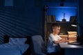 Boy studying at home at night using laptop, student doing homework late evening with computer, online lesson, e-learning Royalty Free Stock Photo