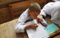 A boy studying and writing homework in arabic