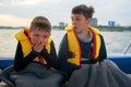 Boy suffers from seasickness on board the boat, closes his mouth with his hands