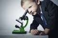 Boy in suit looking in microscope.Smart child.little scientist.Grey background Royalty Free Stock Photo