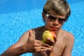 Boy with sun glasses presenting an apple Royalty Free Stock Photo