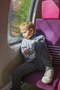 Boy in sunlight on train, missing gadgets. Reflective, digital free. Royalty Free Stock Photo