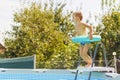 Boy with Surfboard Float by Above-Ground Pool