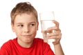 Boy with suspicion looks at glass with water Royalty Free Stock Photo