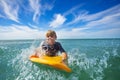 Boy swim on surf board smiling and splashing in waves Royalty Free Stock Photo