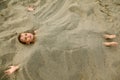 Boy after swimming is buried in sand on beach Royalty Free Stock Photo