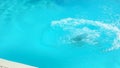 Boy in swimming gogles is jumping into the pool