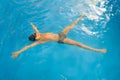 Boy swimming in indoor pool having fun during swim class