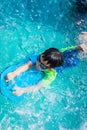 A boy is swimming with kickboard and swimming goggles Royalty Free Stock Photo