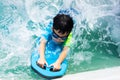 A boy is swimming with kickboard and swimming goggles Royalty Free Stock Photo