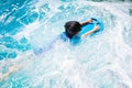 A boy is swimming with kickboard and swimming goggles Royalty Free Stock Photo