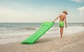 Boy with swimming mattress walks on sand sea beach Royalty Free Stock Photo