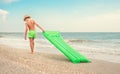 Boy with swimming mattress walks on sand sea beach Royalty Free Stock Photo