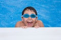 boy swimming in the pool with goggles and a big g Royalty Free Stock Photo