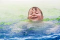 Boy is swimming in an warm outside pool