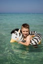 A boy swims, a child with an inflatable lifebuoy in the shape of a zebra. Summer swim. Bathing a child in water. Active