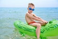 BOY SWIMS IN THE SEA ON THE CROCODYLE TOY Royalty Free Stock Photo