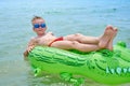 BOY SWIMS IN THE SEA ON THE INFLATABLE CROCODYLE TOY