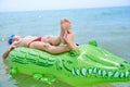 BOY SWIMS IN THE SEA ON INFLATABLE CROCODYLE TOY Royalty Free Stock Photo