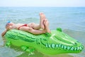 BOY SWIMS IN THE SEA ON INFLATABLE CROCODYLE TOY Royalty Free Stock Photo