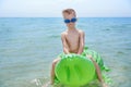 BOY SWIMS IN THE SEA ON INFLATABLE CROCODYLE TOY