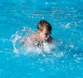 Boy swims with a splash in the water park Royalty Free Stock Photo