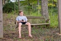 Boy in Swing playing or texting on Phone
