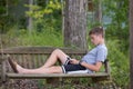 Boy in Swing playing or texting on Phone