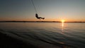 Boy swings from rope over Lake Champlain in Vermont at sunset Royalty Free Stock Photo