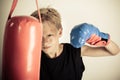 Boy swings single gloved hand at red punching bag Royalty Free Stock Photo