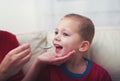 Boy with symptoms hand, foot and mouth disease taking syrup Royalty Free Stock Photo