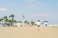 A boy in a T-shirt with sneakers on the sandy Mackenzie beach in Larnaca. Cyprus