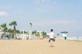 A boy in a T-shirt with sneakers on the sandy Mackenzie beach in Larnaca. Cyprus