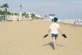 A boy in a T-shirt with sneakers on the sandy Mackenzie beach in Larnaca. Cyprus