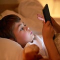 Boy, tablet and bed with night, learning and relaxing for social media or learning. Child, bedroom and connectivity for Royalty Free Stock Photo