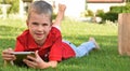 Boy with a tablet lies on the grass Royalty Free Stock Photo