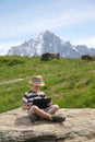 Boy with tablet PC sit on stone Royalty Free Stock Photo