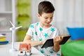 Boy with tablet, toy house and wind turbine Royalty Free Stock Photo