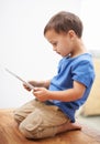 Boy, tablet and typing with games, relax or internet with network, connection or home. Child development, apartment or Royalty Free Stock Photo