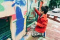 Boy tagging wall with graffiti
