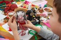 Boy tailor learns to sew, dress for doll, handmade and handicraft concept