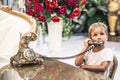 Boy take telephone receiver, play with antique vintage rotary old landline hang up phone beautifully embossed gold