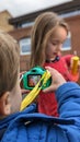 Boy takes photograph of girl with his new toy camera